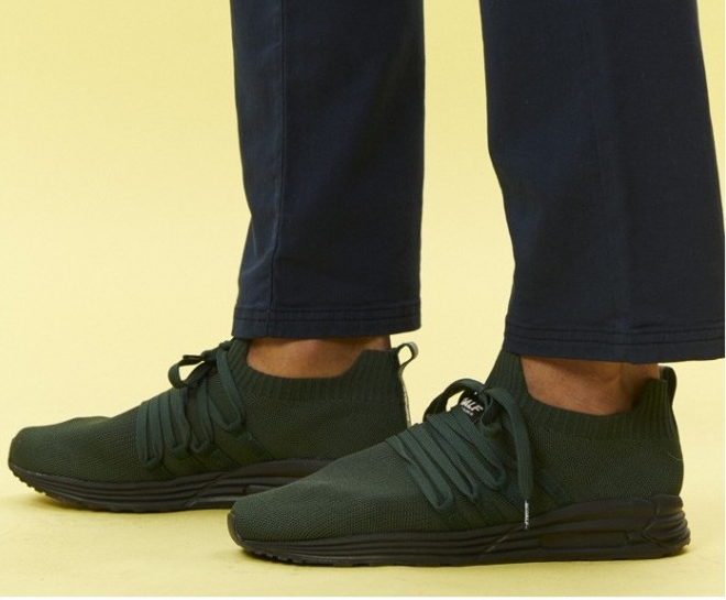 Mann trägt Sneakers von der Marke Ecoalf.
